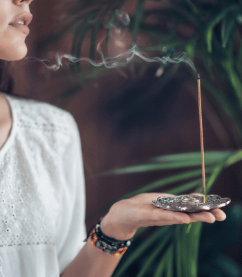 woman burning an incense to energetically cleanse her space
